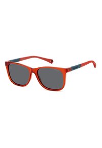 Lunettes de soleil translucides rouges avec des verres gris ; design rectangulaire et surdimensionné ; branches fines et courbées ; accent métallique sur la branche.