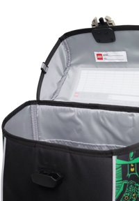 Geantă LEGO neagră cu interior gri, având un suport transparent pentru eticheta de nume și un mecanism de închidere sigur în partea de sus.