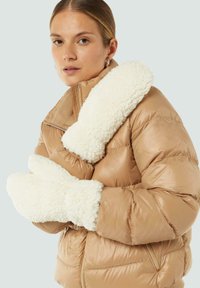 Beige Pufferjacke mit einem strukturierten weißen Kunstfellkragen und passenden Fäustlingen. Die Jacke verfügt über einen Reißverschluss und vordere Taschen.