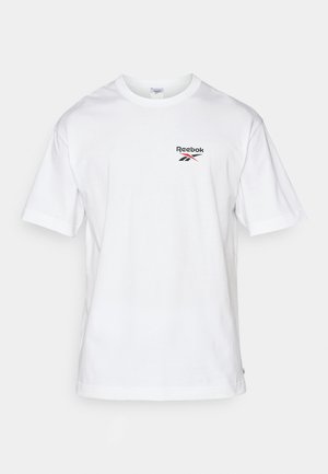T-shirt en coton blanc à manches courtes, col rond, avec logo Reebok noir/rouge sur la partie gauche de la poitrine. Texture lisse, coupe standard.