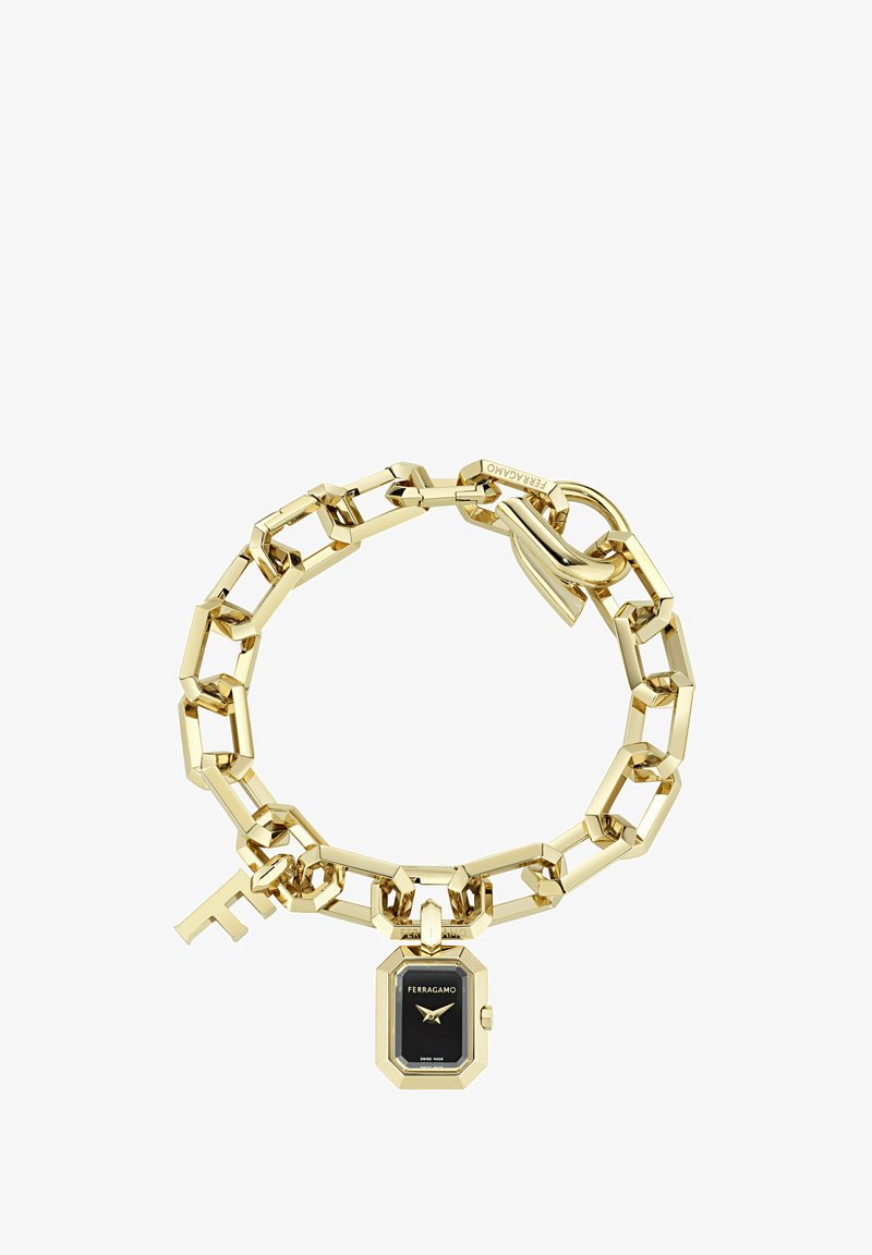 Zelta ķēdes aproce ar taisnstūra gredzeniem, melnu Ferragamo pulksteņa piekariņu un piekaramo slēdzeni ar gravējumu Ferragamo.