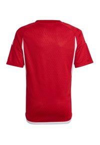 Camiseta deportiva roja con un patrón texturizado, mangas cortas y acentos laterales blancos. Diseño de cuello redondo, fabricada con un material ligero y transpirable.