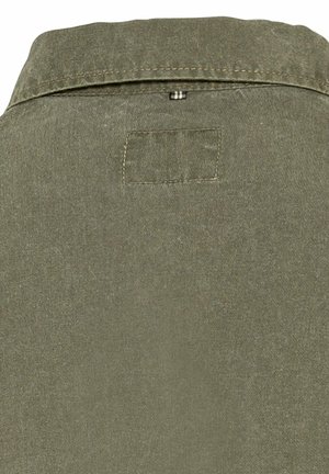 Olijfgroene blouse met een kraag, voorzien van een rechthoekige patch en zichtbare stiksel. De stof lijkt zacht en gestructureerd te zijn.
