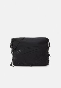 Black messenger bag made of durable fabric, features a textured front design, adjustable strap, and drawstring closure on both sides.
