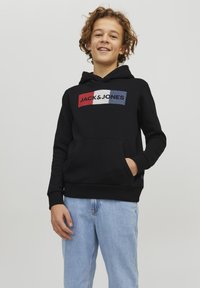 Felpa nera con cappuccio, dotata di tasca frontale a marsupio, caratterizzata da un design grafico rettangolare multicolore con il testo "JACK & JONES". Materiale in cotone.