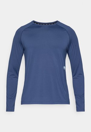 Chemise à manches longues bleu marine en tissu lisse. Dotée d'un col rond et de manches raglan. Comprend un petit logo sur le côté inférieur.