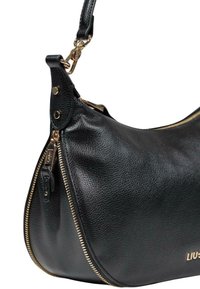 Bolso de mano de piel negra con un acabado texturizado, que presenta un detalle de cremallera dorada, una correa desmontable y un acento de logo dorado.