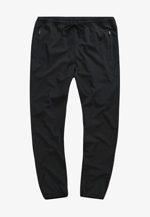 Černé sportovní kalhoty s hladkým povrchem, elastickým pasem, stahovací šňůrkou a kapsami na zip po stranách. Zúžený střih nohavic.