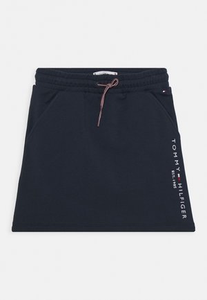 Marineblauer Rock mit elastischem Bund und Kordelzug, Seitentaschen und weißem, vertikal verlaufendem "Tommy Hilfiger EST. 1985" Logo auf der rechten Seite.