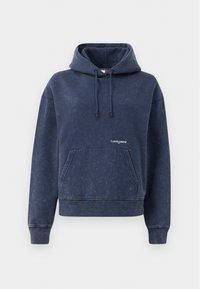 Marineblå hettegenser laget av bomullsblanding med en frontlomme, snor i hetta, og en liten logo på brystet. Myk, strukturert overflate.