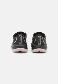 Czarne buty sportowe z różowymi akcentami i siateczkową cholewką, wyposażone w wyprofilowaną podeszwę oraz oznaczenie na pięcie, zaprojektowane z myślą o komforcie i wsparciu.