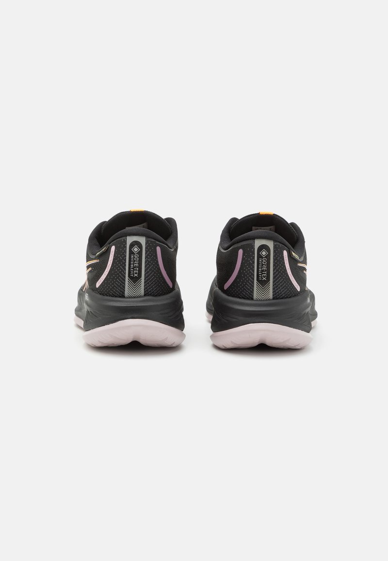 Chaussures de sport noires avec des accents roses et une tige en mesh, dotées d'une semelle rembourrée et d'un onglet de talon de marque, conçues pour le confort et le soutien.