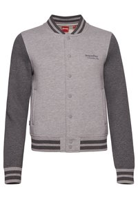 Veste universitaire grise avec manches gris foncé. Fabriquée en tissu doux, elle comprend des boutons pression, deux poches latérales, ainsi que des poignets et un ourlet côtelés rayés.