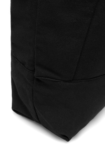 Fekete vászontáska szerkezetes formával, látható varrásokkal és texturált felülettel. A design jellemzői közé tartozik egy hajtott alsó sarok és letisztult vonalak.