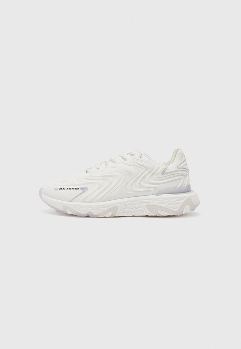 White athletic sneaker with wavy design details, textured upper, and a thick, cushioned sole. Features a subtle logo along the side.