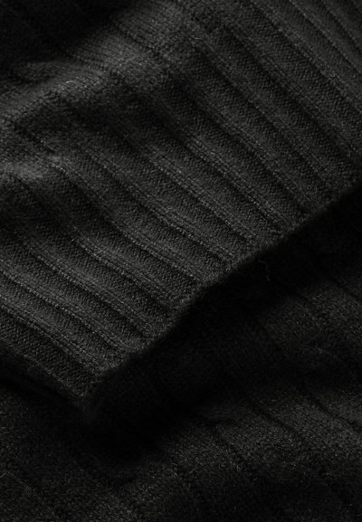 Tecido de malha preto com um padrão canelado, apresentando uma textura suave e diferentes espessuras. O tecido parece quente e aconchegante.