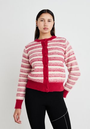 Cardigan rayé rouge et crème avec un tricot texturé. Présente un col rond et une rangée de six gros boutons assortis à l'avant.