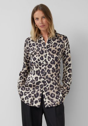 Chemise à boutons imprimée léopard en beige et noir, avec un col et des manches longues, fabriquée en tissu lisse et léger.