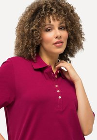 Pánská polokošile s krátkým rukávem v hluboké magentě, vyrobena z texturované bavlny. Obsahuje zapínání na knoflíky se světlými knoflíky a klasický límeček.