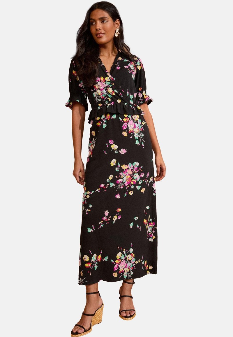 Musternähe mustriline mustrituuletus, lühikeste puhv-ületitega ja kihilise rühi detailiga. Kandmisel on platvormsandaalid.