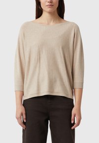 Beżowy, oversizeowy sweter z szerokim dekoltem w łódkę, rękawami o długości do łokcia i prążkowanym wykończeniem na dole. Miękka faktura, luźny krój.