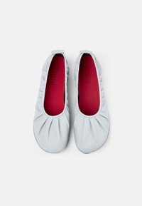 Bailarinas de cuero gris claro con detalles fruncidos y punta redonda, con una plantilla roja y textura suave.