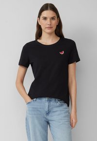 Zwarte katoenen T-shirt met een ronde halslijn en korte mouwen, met een kleine geborduurde watermeloenschelp in rood en wit.