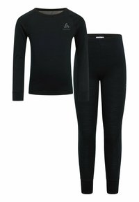 Ensemble composé d'un haut à manches longues noir et d'un legging en matériau doux, avec une coupe ajustée, comportant un petit logo en haut à gauche du haut.