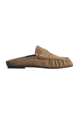 Tanfarvet ruskind slip-on mule loafer med syningsdetaljer og flad sort sål, vist i sideprofil mod en hvid baggrund.