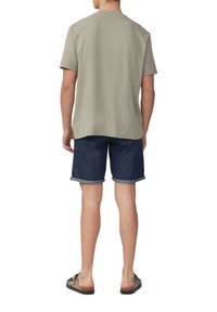 Grijs gestructureerd shirt met korte mouwen, marineblauwe denimshorts met omgeslagen pijpen en bruine slippers, gezien van achter.