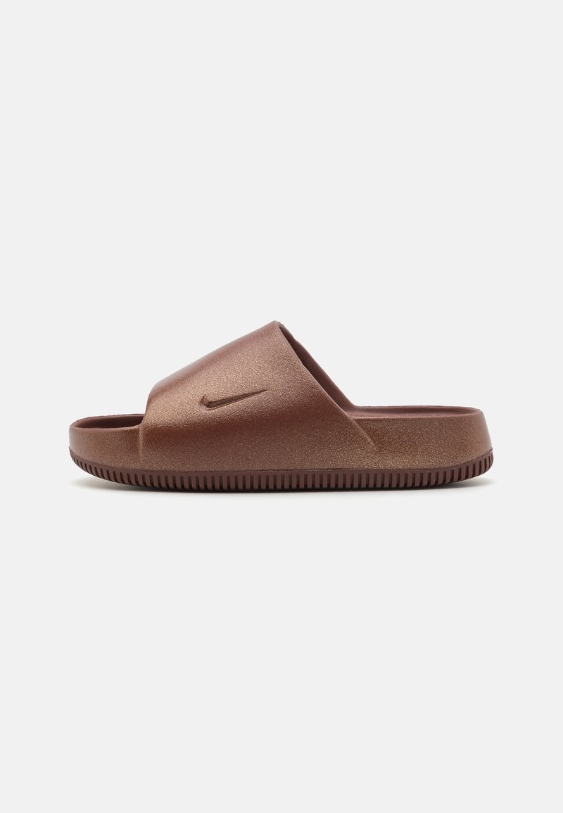 Barna Nike csúszásgátló szandál széles pánttal, sima textúrával és enyhe fényű felülettel. Dombornyomott talppal rendelkezik a tapadás érdekében, és egy kis logó található a pánton.