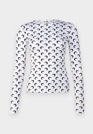 Long-sleeve white top featuring a repeating black crescent moon pattern. Made of smooth fabric, fitted design with a crew neckline.