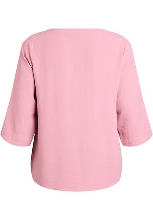 Rosa långärmad topp med avslappnad passform och enkel rund halsringning. Texturen är lätt upphöjd, vilket förstärker dess visuella intresse.