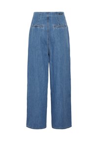 Pantalon en jean bleu taille haute à jambes larges avec deux poches passepoilées à l’arrière et une petite étiquette de marque noire sur la taille.