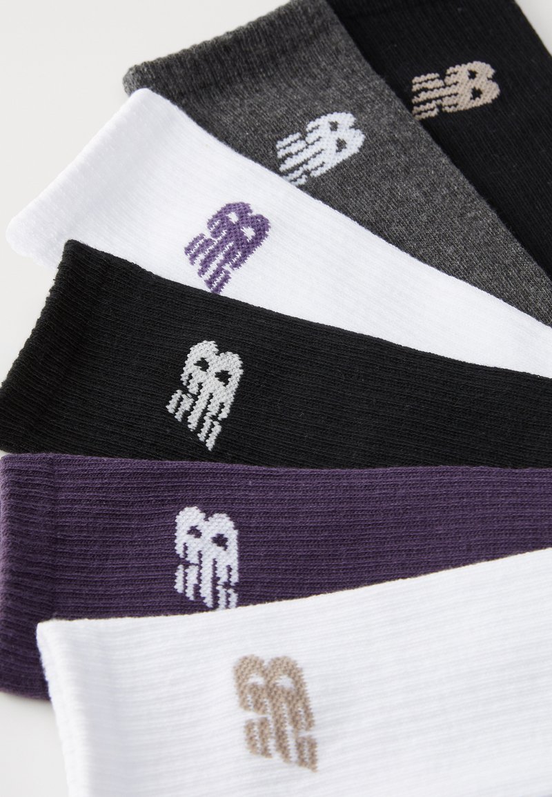 Six paires de chaussettes en noir, blanc, gris et violet, présentant une texture côtelée et un petit logo brodé sur chaque chaussette.