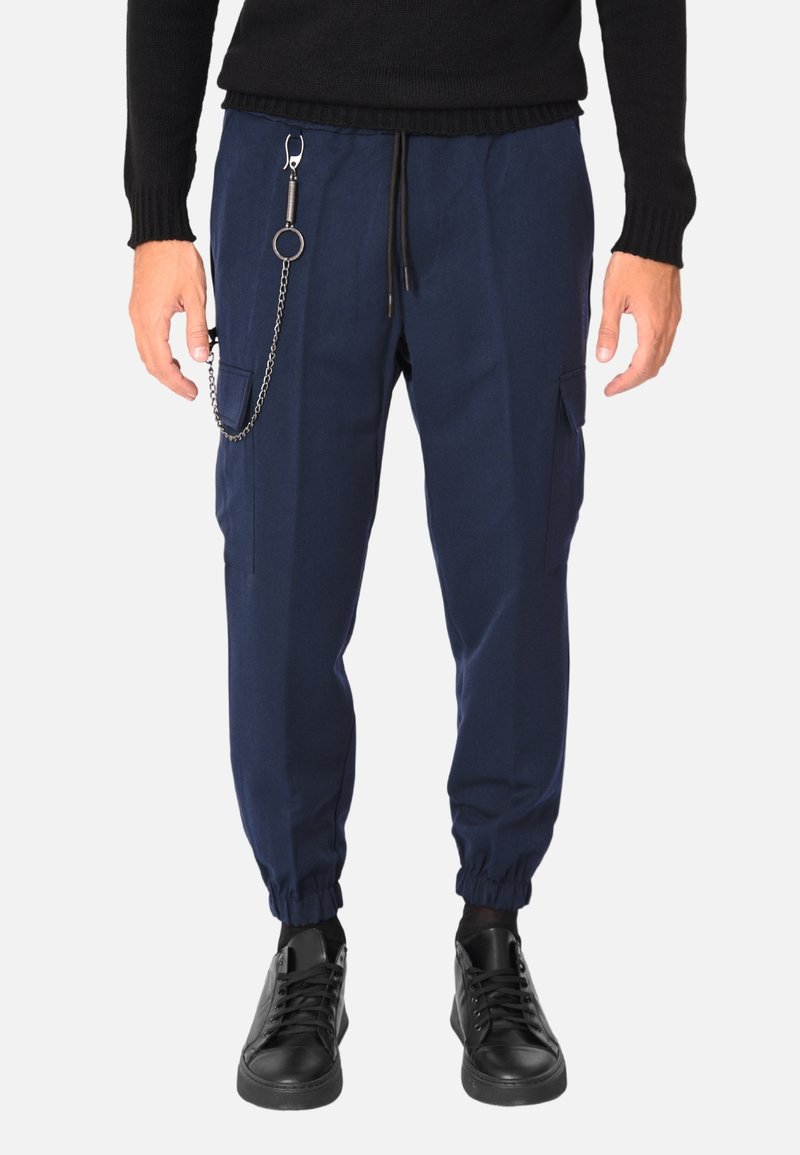 Pantaloni jogger blu navy con vita a coulisse, tasche laterali, polsini elasticizzati e un dettaglio decorativo di una catena argentata sul lato sinistro.