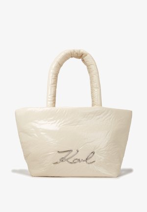 Sac à main matelassé, de couleur crème brillante, avec des poignées arrondies et un logo script métallique "Karl" à l'avant.