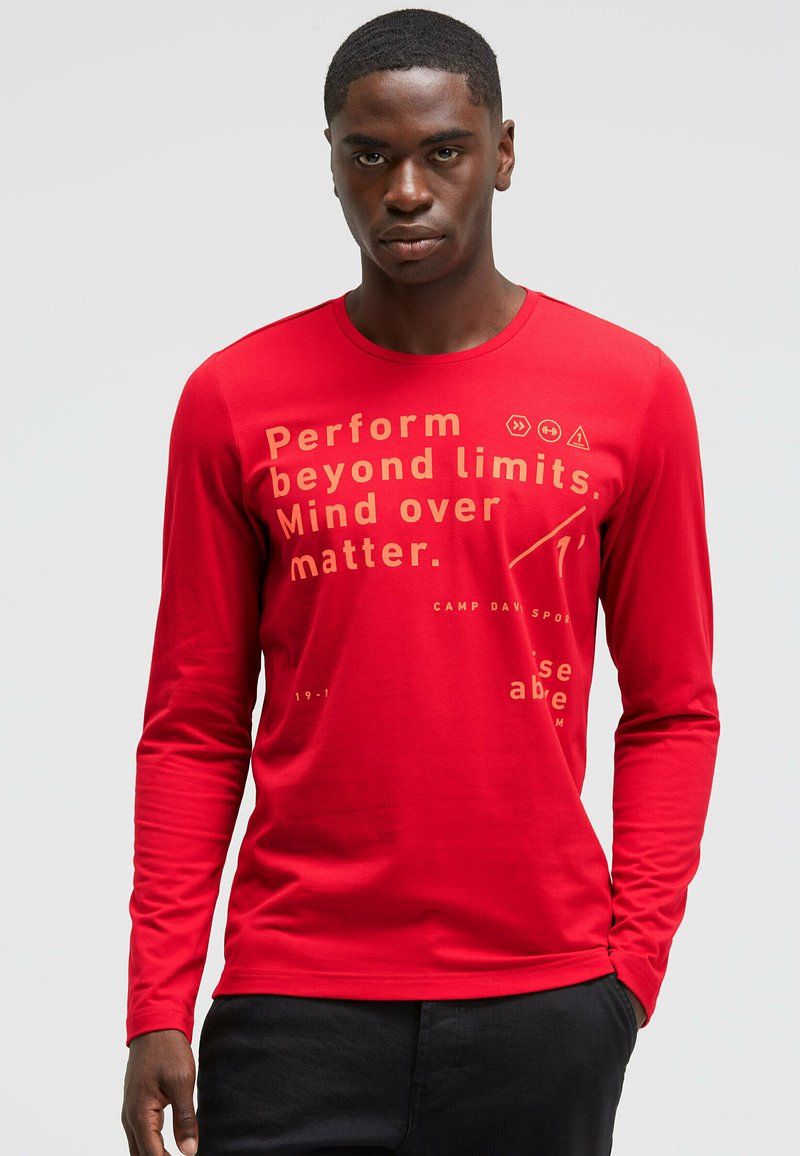 Red long-sleeve t-shirt made of soft fabric, featuring gold text and graphic designs, crew neck, and a slim fit. Text includes motivational phrases.