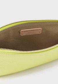 Zöld bőr patentos tolltartó texturált felülettel, sima bélés belül, logó címkével. A cipzár aranyszínű.