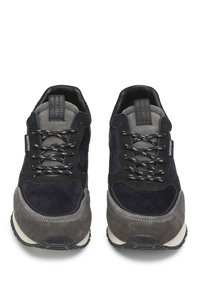 Sneakers che presentano una combinazione di suede grigio scuro e blu navy, con dettagli testurizzati, lacci neri e una suola in gomma bianca.