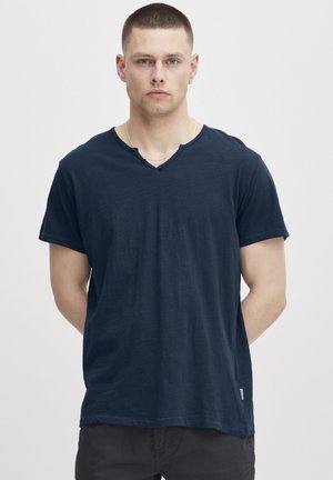 Navy blue cotton t-shirt with short sleeves, v-neckline, and a textured finish. Features a small label on the lower side.