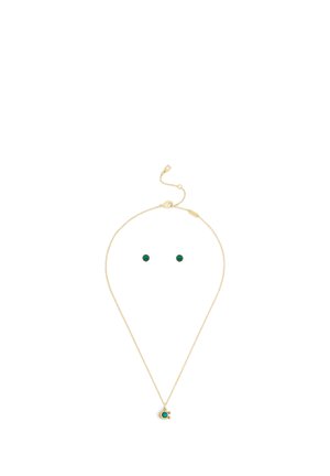 Collier en or et ensemble de clous d'oreilles assortis avec des pierres précieuses vertes rondes sur fond blanc.