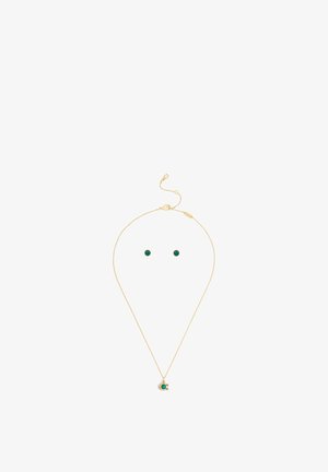 Collier en or et ensemble de clous d'oreilles assortis avec des pierres précieuses vertes rondes sur fond blanc.