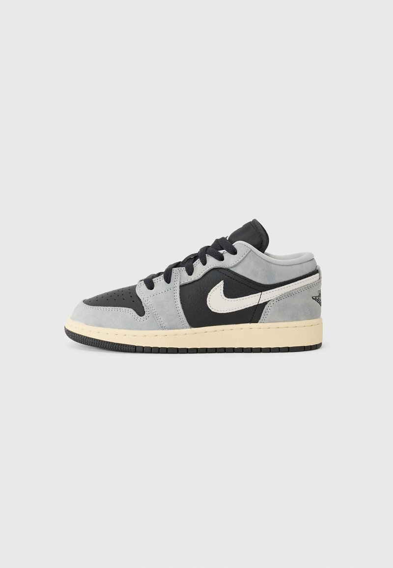 Sneaker med en design av grå mocka och svart läder, vit Nike swoosh, svart gummisula och vadderad krage.