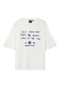 Biała, oversize koszulka z krótkim rękawem, z niebieskim ręcznie napisanym tekstem i graficznymi ikonami, wykonana z miękkiej bawełny.
