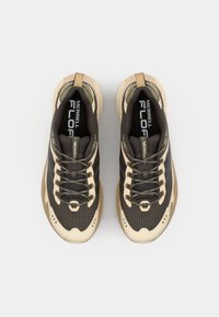 Black and beige hiking shoes with mesh upper, patterned textile, padded collar, and contrasting laces. Features a cushioned sole and logo accents.