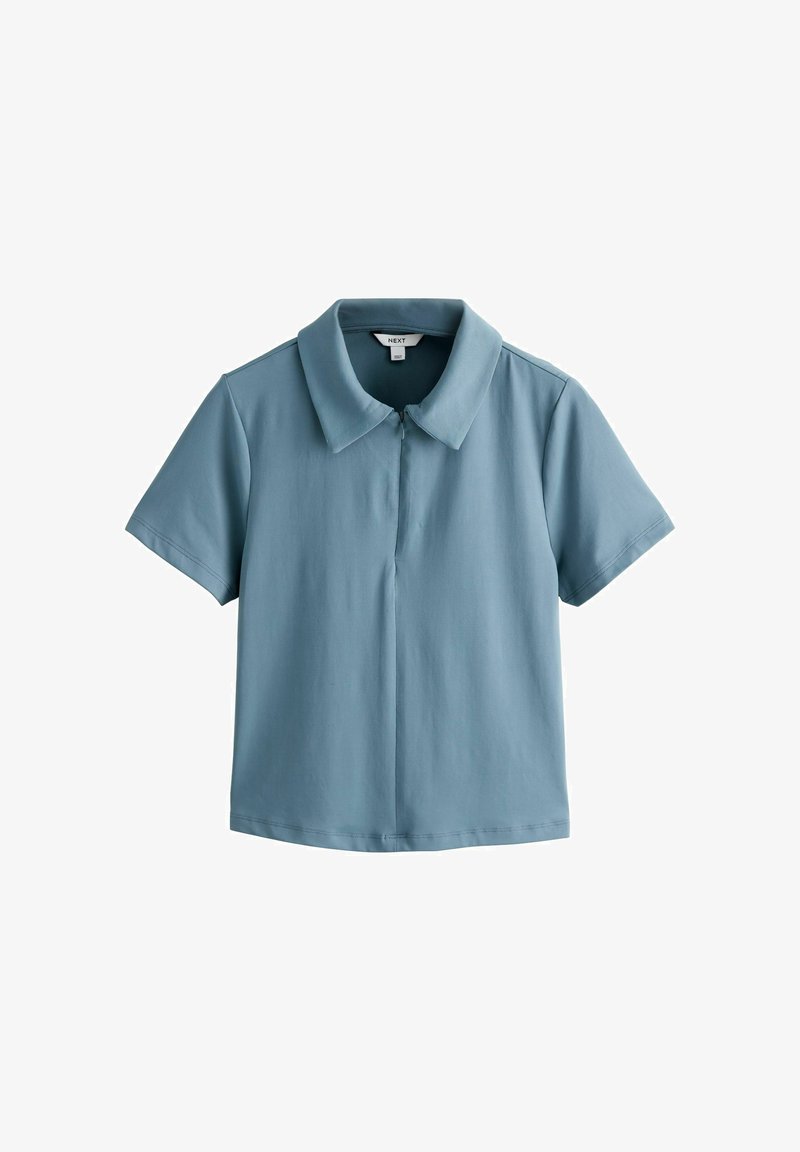 Polo à manches courtes bleu clair avec un large col et des boutons cachés sur le devant, présenté sur un fond blanc uni.