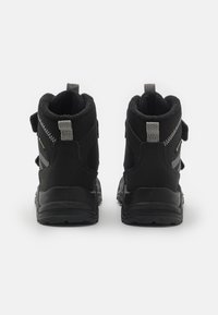 Schwarze Wanderschuhe mit strukturiertem Obermaterial, verstellbaren Riemen und verstärkter Ferse. Sie verfügen über einen gepolsterten Schaft und eine Gummisohle für besseren Halt.
