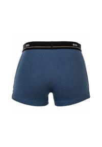 Boxer-briefs bleus pour hommes en tissu doux. Présentent une taille noire avec le logo "BOSS" et un accent doré. Taille intermédiaire et coupe ajustée.