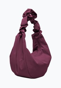 Bolso de hombro de tela morada con un diseño suave y arrugado. Presenta una forma holgada y una parte superior ajustable con cordón. Textura suave y acentos minimalistas.